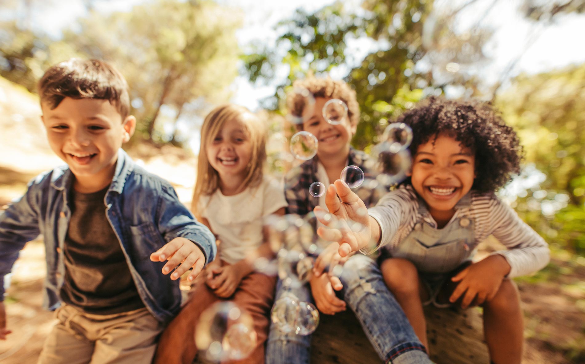 Children playing with bubbles outdoors.